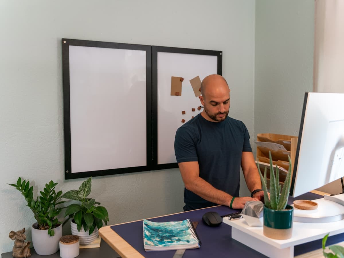 A professional working upright at a standing desk in a home office